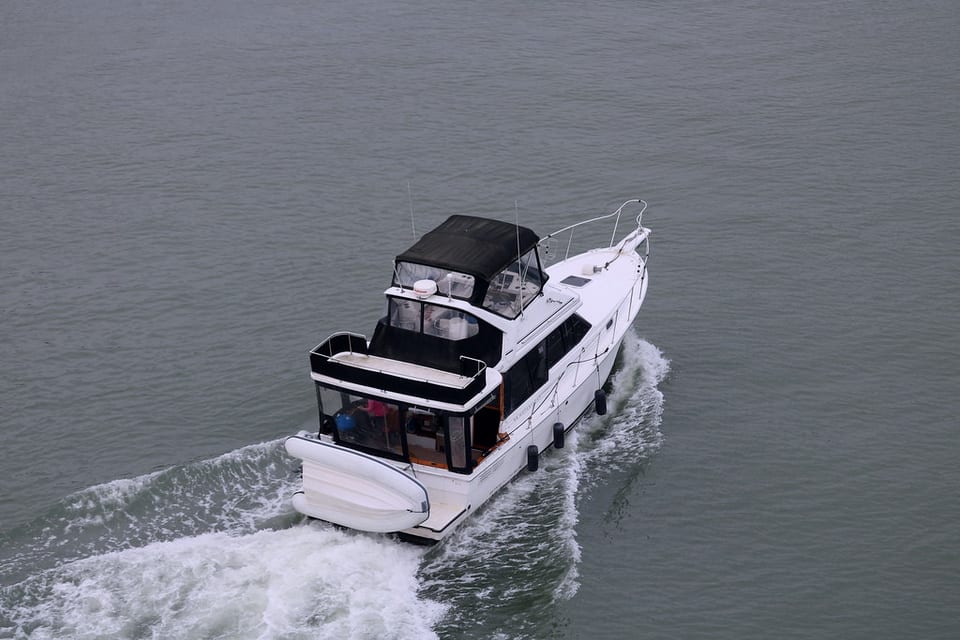 A motor cruiser under way, seen from above, throwing a wake.